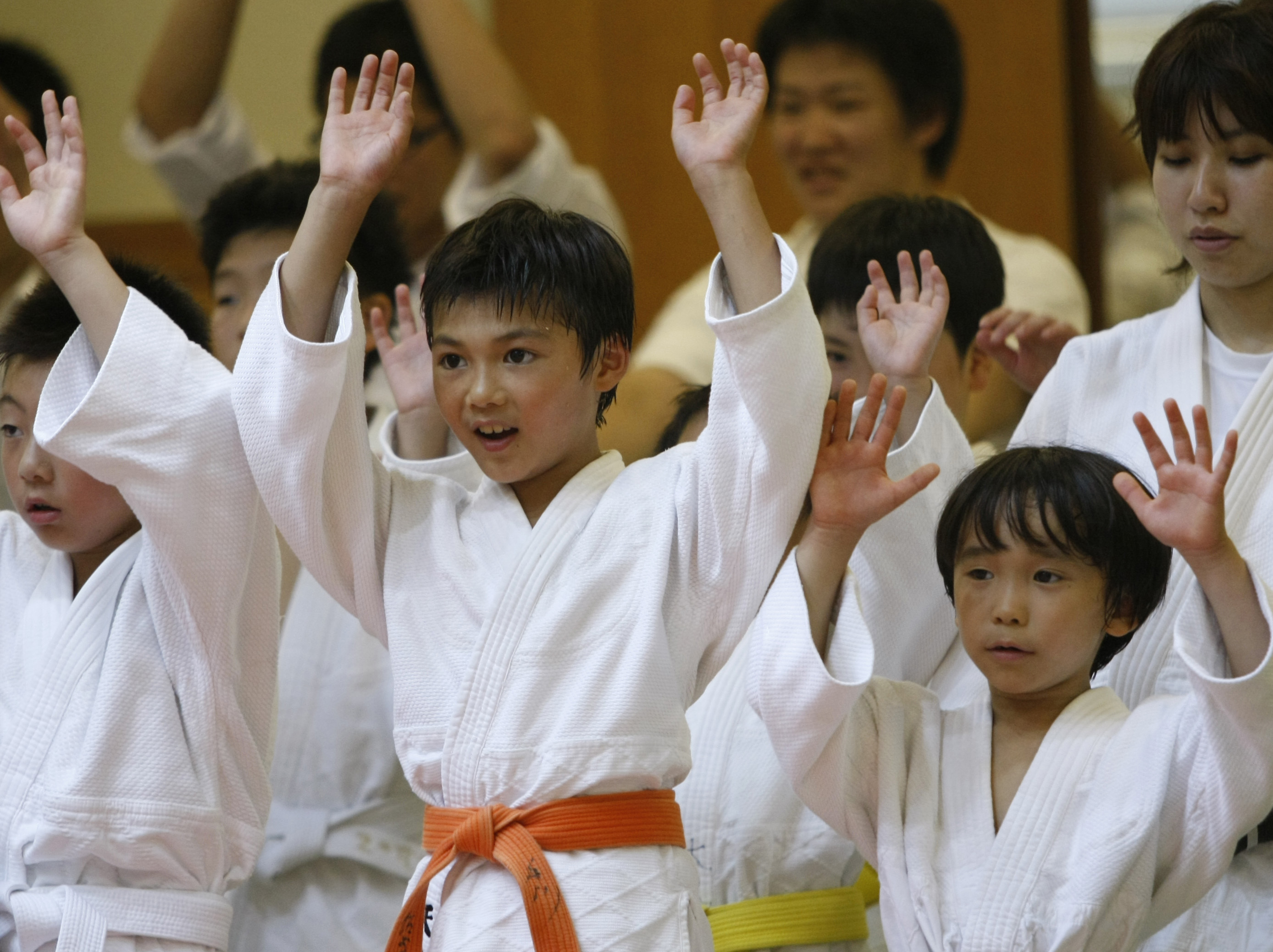 Children cheer on Japan's national judo team at a ceremony in Tokyo